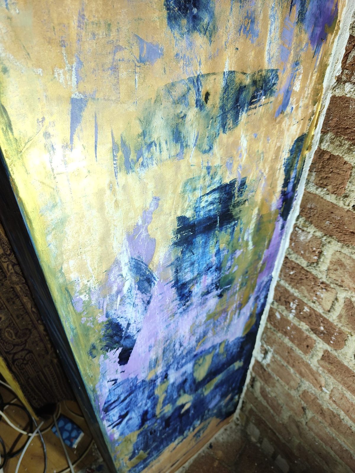 De zijkant van de doorgang van dichtbij, goud met blauw en violet naast oude baksteen