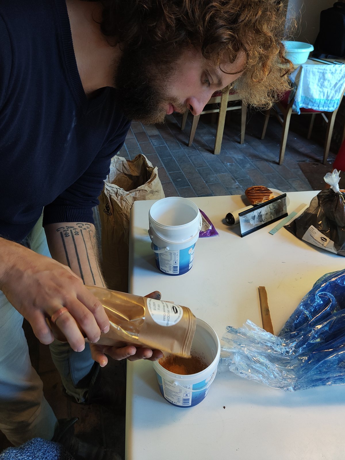 De maker mengt pigment aan tafel
